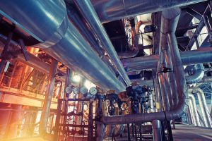 Equipment, cables and piping as found inside of a modern industrial power plant. Industrial zone, Steel pipelines, valves, cables and walkways