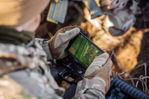 soldiers holding gps in hand and determines the location of coordinates. militaryand technology concept